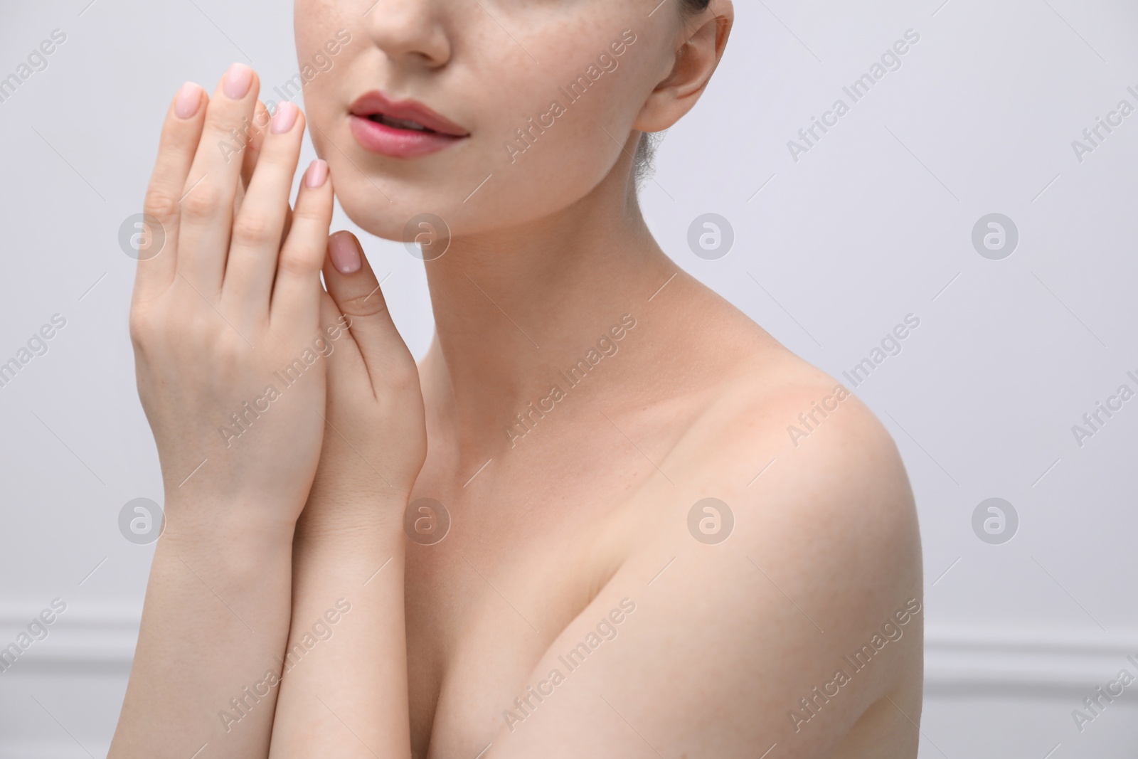 Attractive woman against light background, closeup on shoulder Photo of Attractive woman against light background, closeup on shoulder