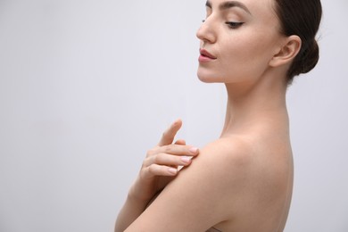 Photo of Attractive woman against light background, closeup on shoulder. Space for text