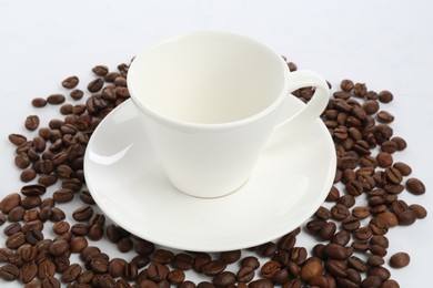Photo of Ceramic cup with roasted coffee beans isolated on white
