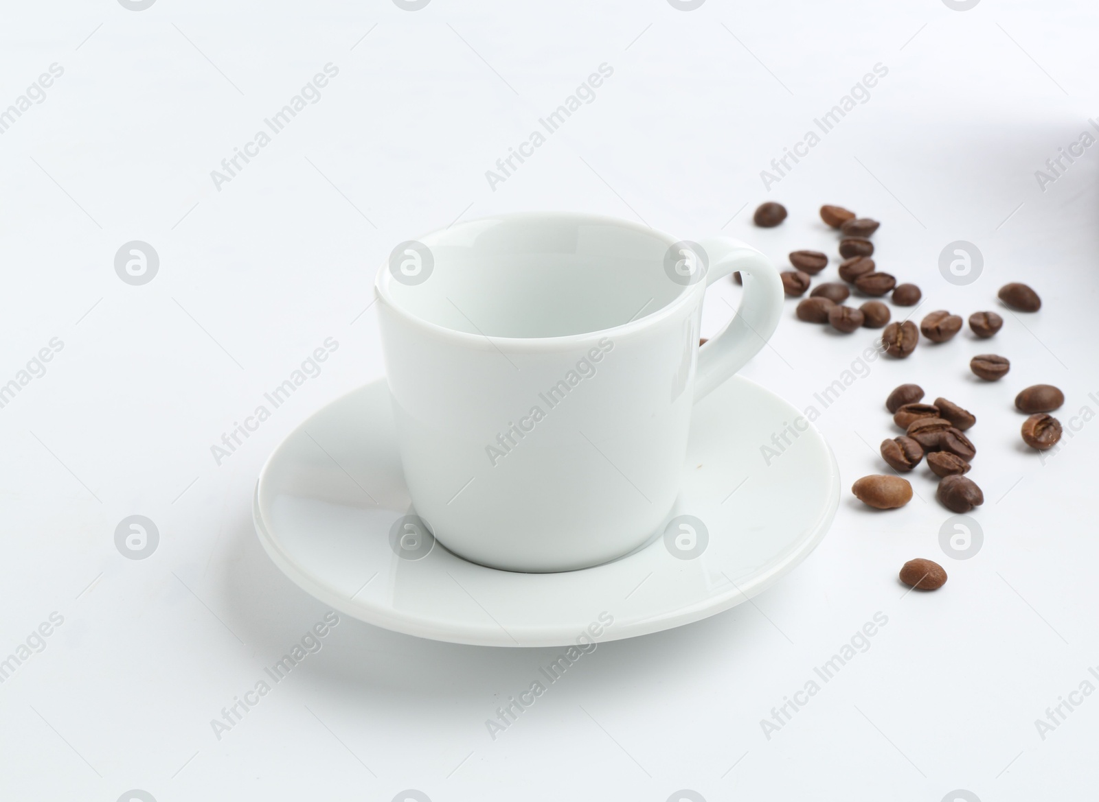 Ceramic cup with roasted coffee beans isolated on white Photo of Ceramic cup with roasted coffee beans isolated on white