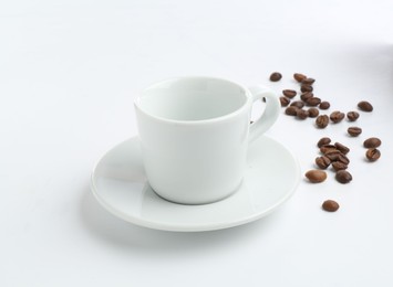 Photo of Ceramic cup with roasted coffee beans isolated on white