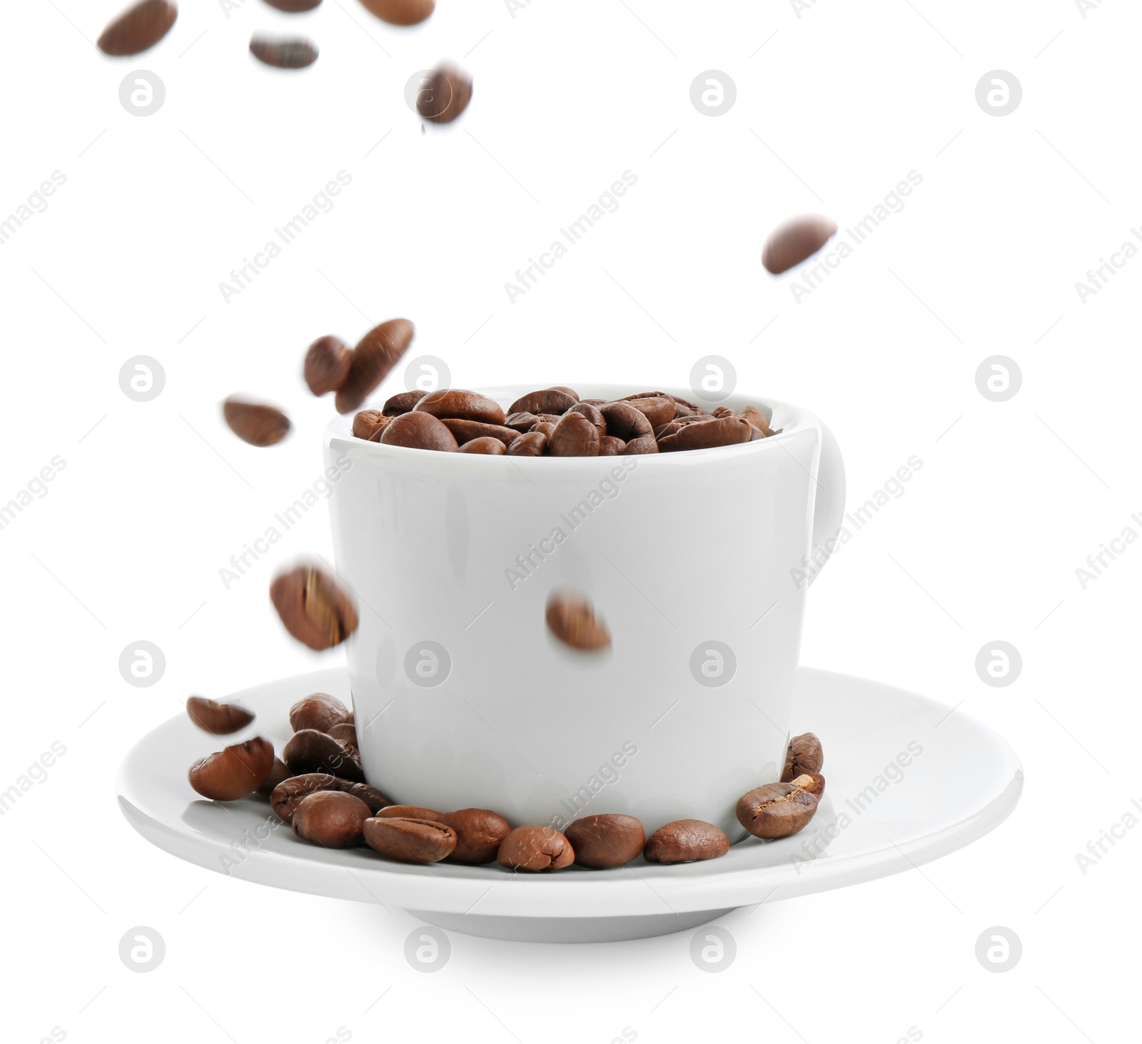 Roasted coffee beans falling into cup isolated on white Photo of Roasted coffee beans falling into cup isolated on white