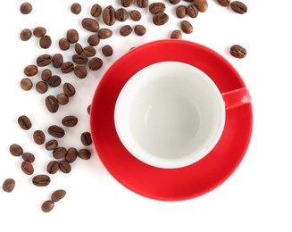 Photo of Ceramic cup with roasted coffee beans isolated on white, top view