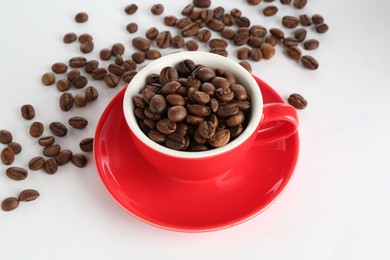 Photo of Ceramic cup with roasted coffee beans on white background