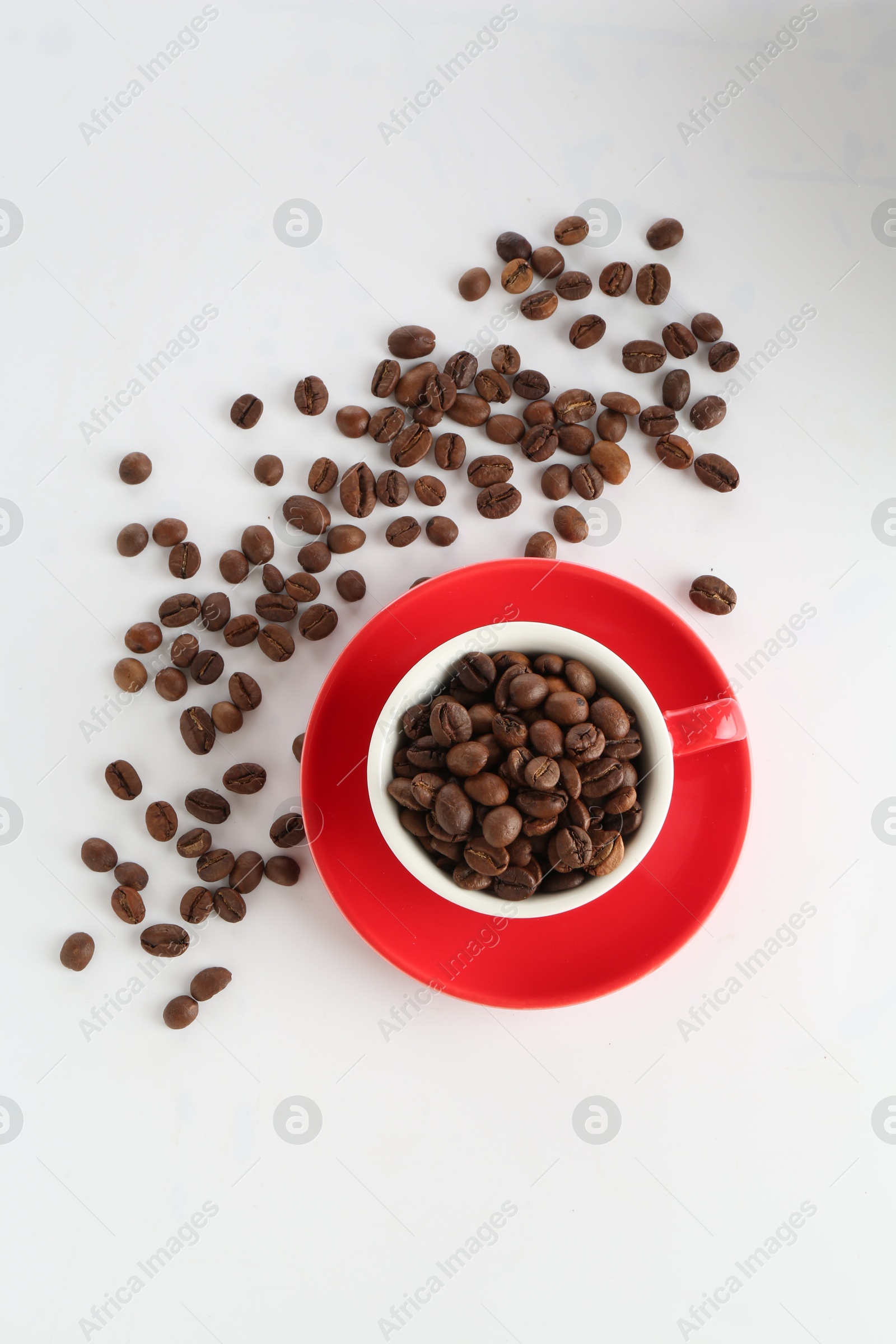 Ceramic cup with roasted coffee beans on white background, top view Photo of Ceramic cup with roasted coffee beans on white background, top view