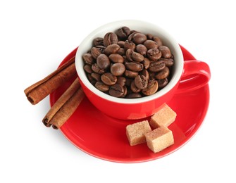 Photo of Ceramic cup with roasted coffee beans, sugar cubes and cinnamon isolated on white