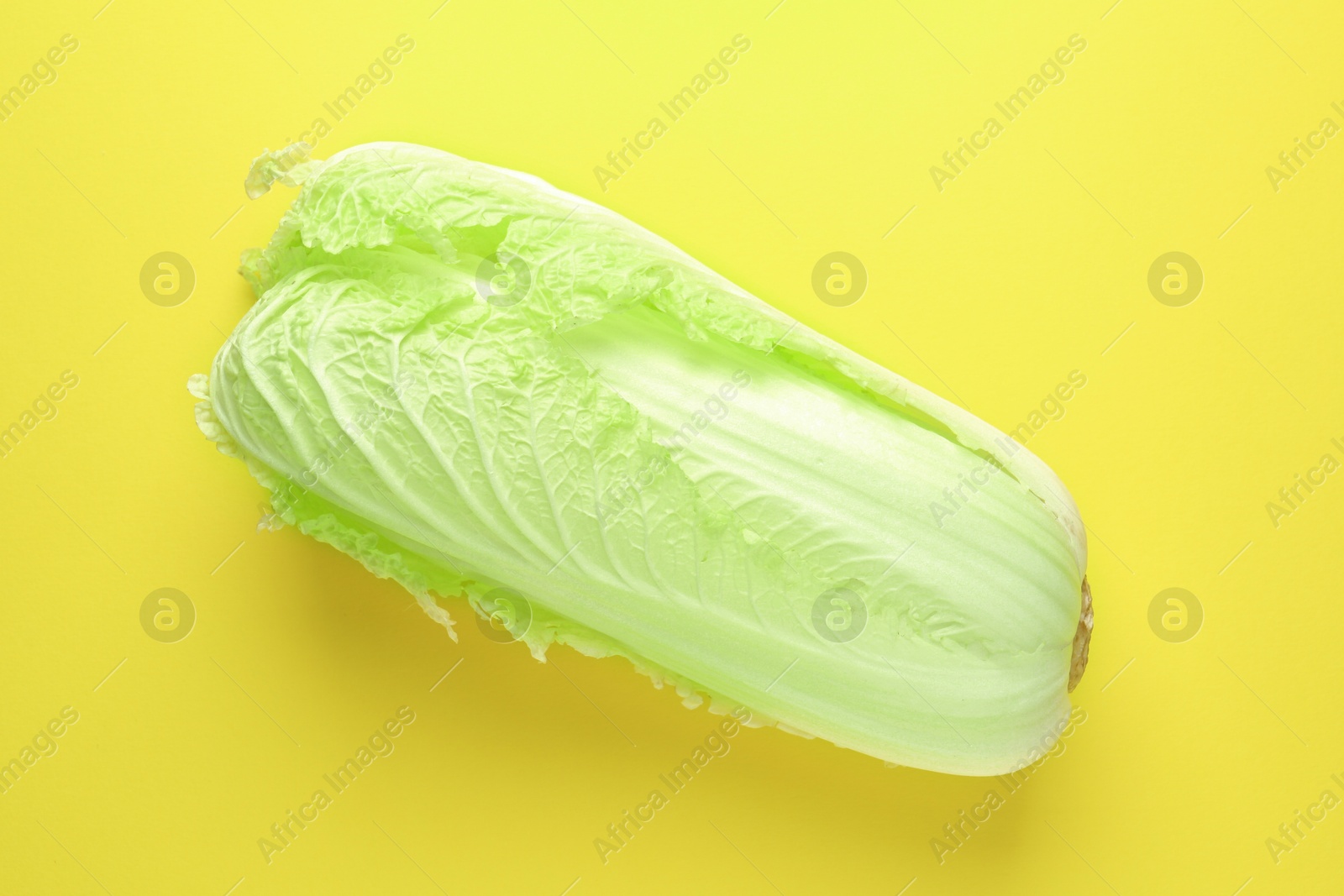 Photo of One fresh Chinese cabbage on yellow background, top view