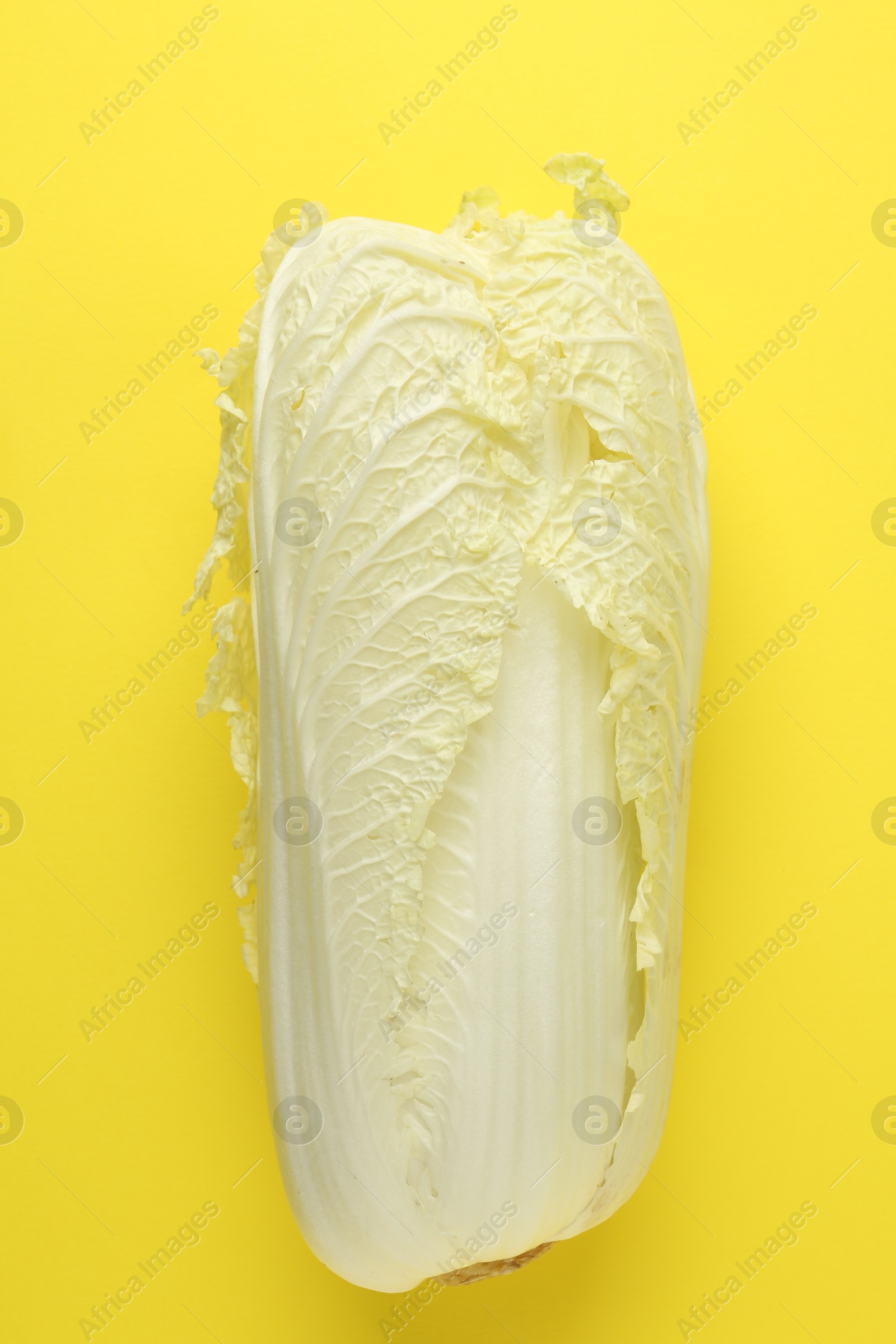 Photo of One fresh Chinese cabbage on yellow background, top view