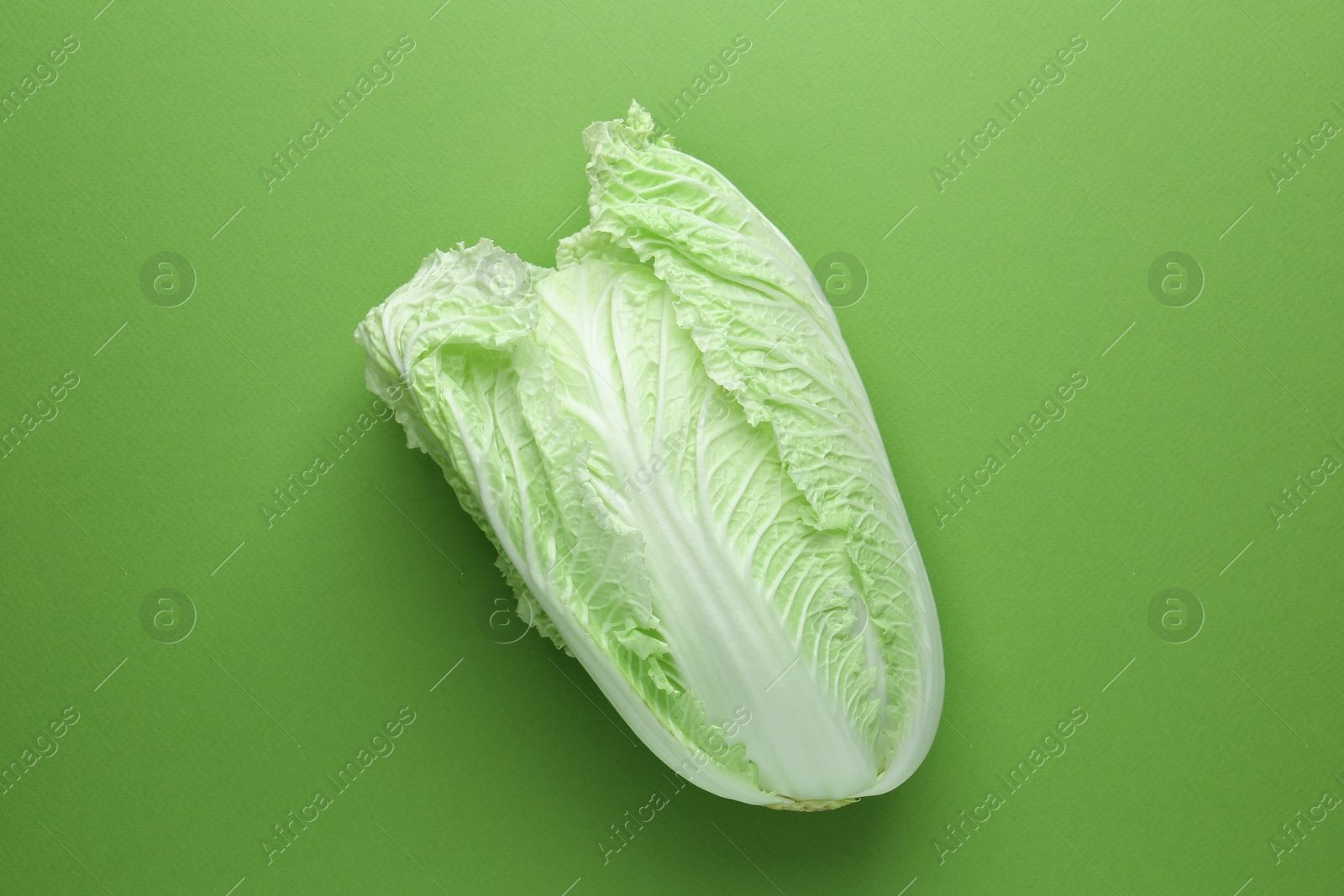 One fresh Chinese cabbage on green background, top view Photo of One fresh Chinese cabbage on green background, top view