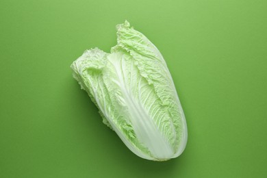 Photo of One fresh Chinese cabbage on green background, top view
