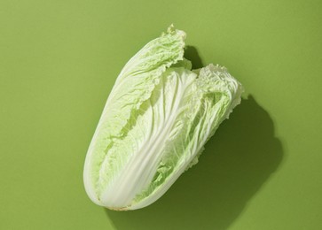 Photo of One fresh Chinese cabbage on green background, top view