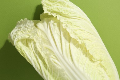 Photo of One fresh Chinese cabbage on green background, top view
