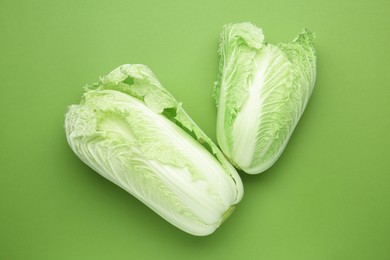 Photo of Fresh Chinese cabbages on green background, top view