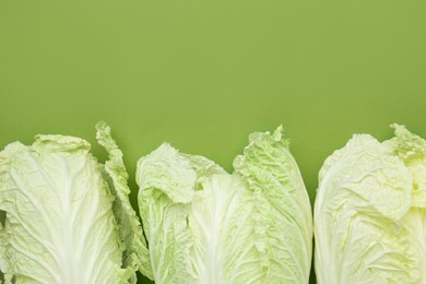 Photo of Fresh Chinese cabbages on green background, flat lay. Space for text