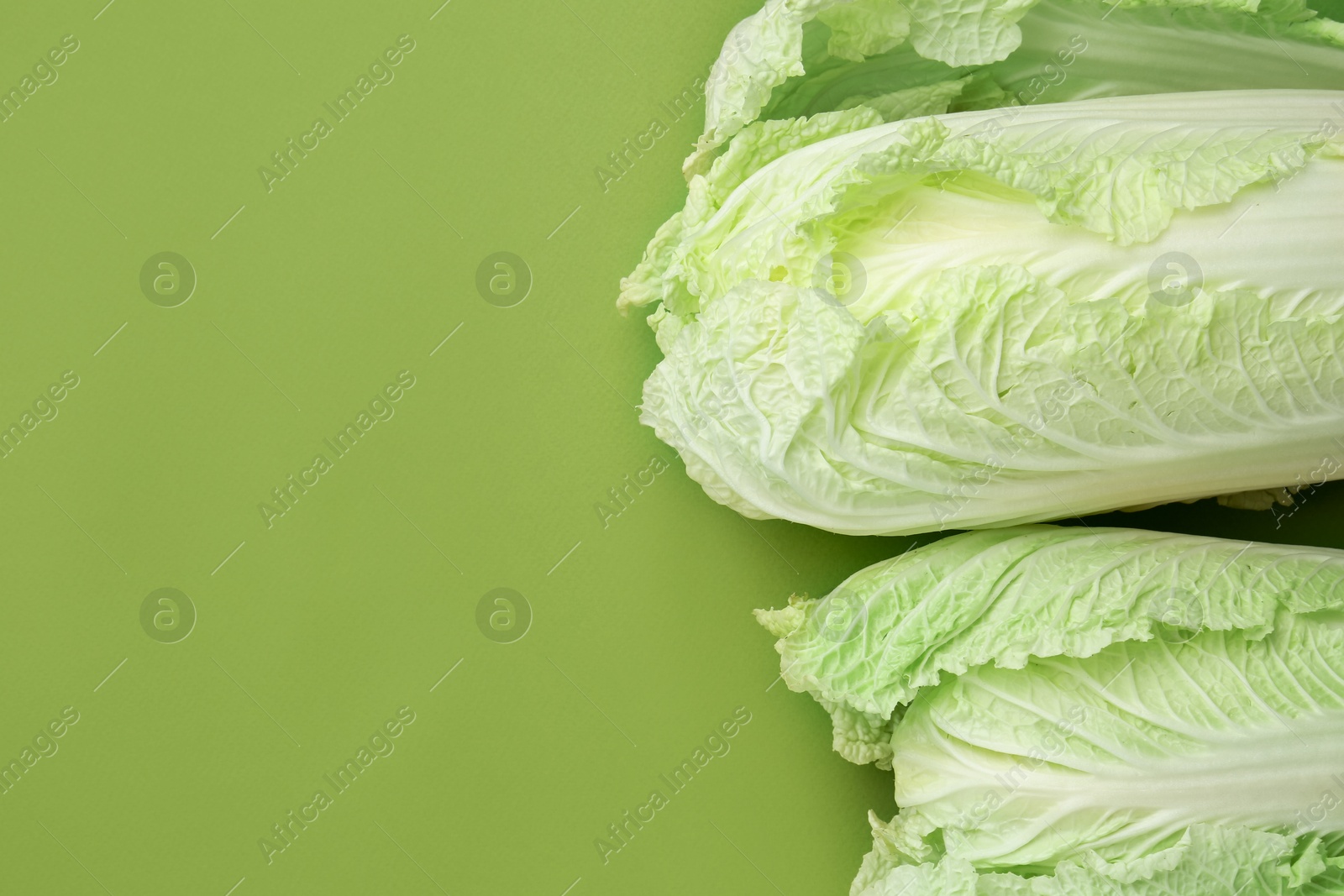 Fresh Chinese cabbages on green background, top view. Space for text Photo of Fresh Chinese cabbages on green background, top view. Space for text