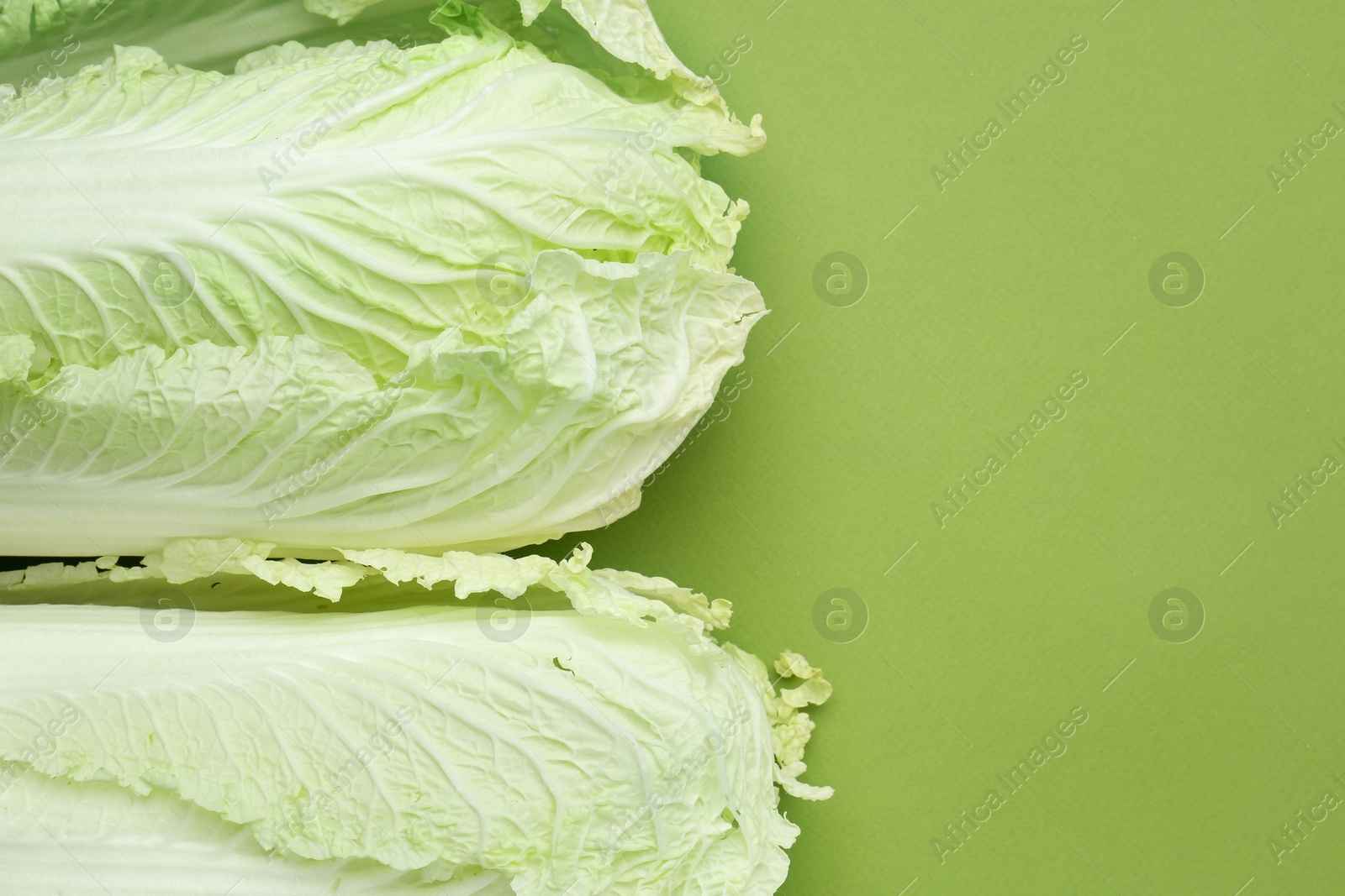 Fresh Chinese cabbages on green background, top view. Space for text Photo of Fresh Chinese cabbages on green background, top view. Space for text