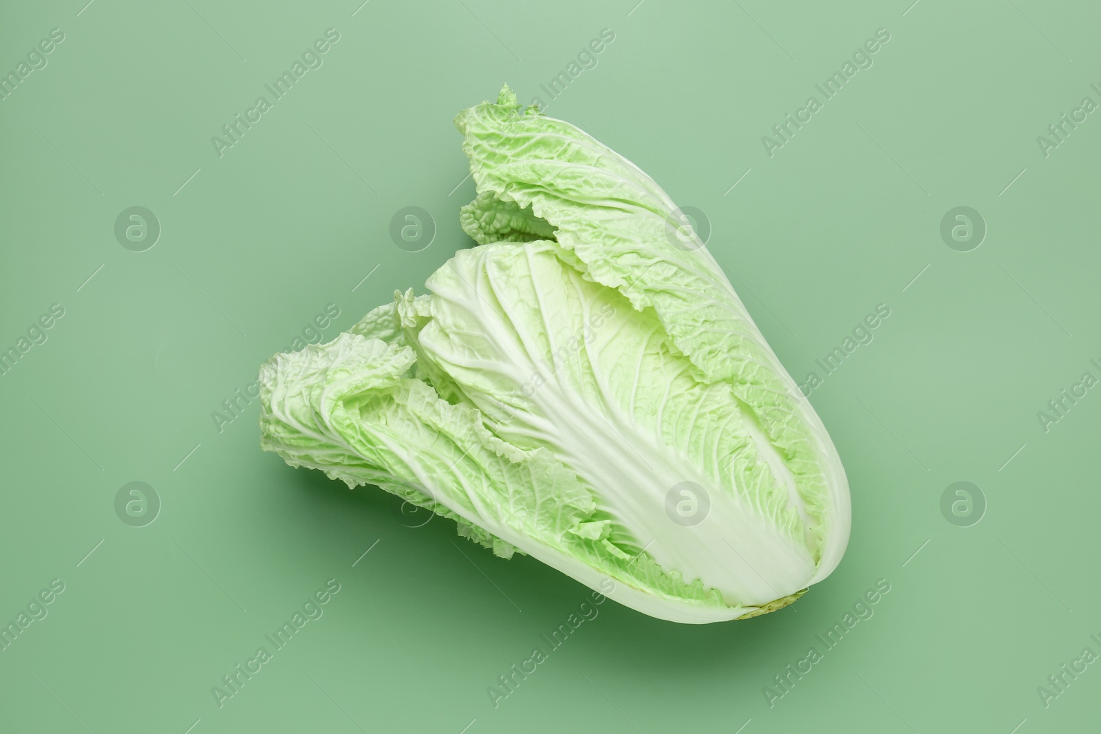One fresh Chinese cabbage on green background, top view Photo of One fresh Chinese cabbage on green background, top view