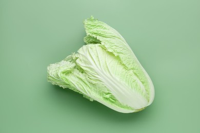 Photo of One fresh Chinese cabbage on green background, top view