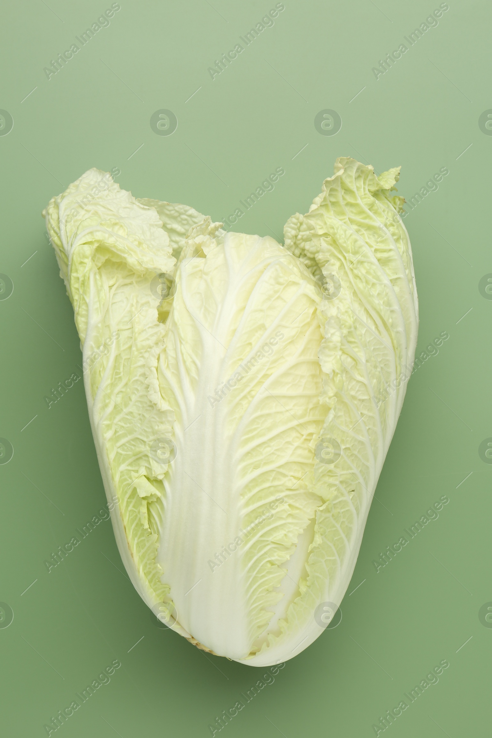 One fresh Chinese cabbage on green background, top view Photo of One fresh Chinese cabbage on green background, top view