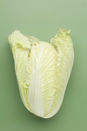 Photo of One fresh Chinese cabbage on green background, top view