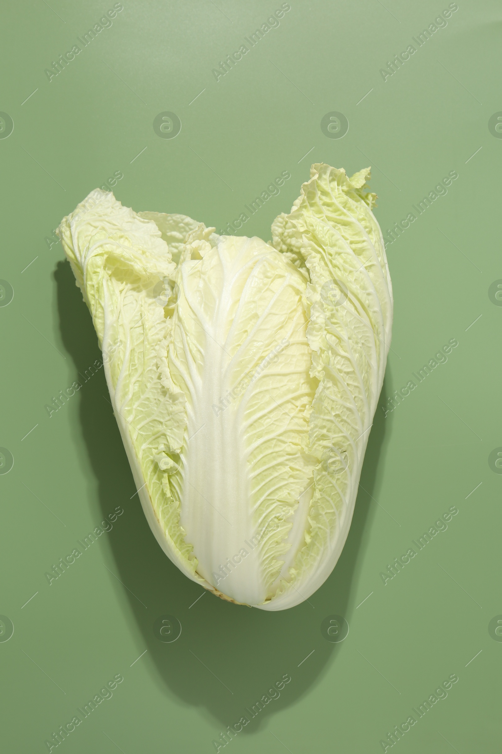 One fresh Chinese cabbage on green background, top view Photo of One fresh Chinese cabbage on green background, top view
