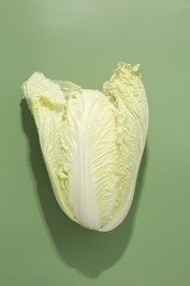 Photo of One fresh Chinese cabbage on green background, top view