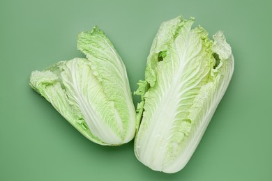 Photo of Fresh Chinese cabbages on green background, top view