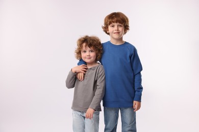 Photo of Cute little brothers posing on white background