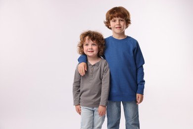 Photo of Cute little brothers posing on white background. Space for text