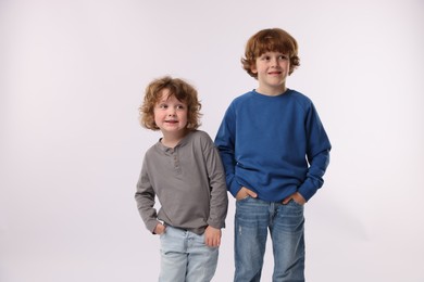Photo of Cute little brothers posing on white background