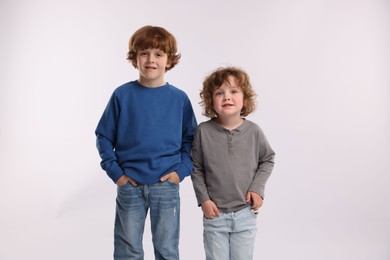 Photo of Cute little brothers posing on white background