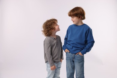 Photo of Cute little brothers posing on white background