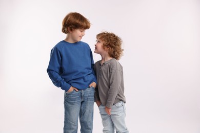 Photo of Cute little brothers posing on white background