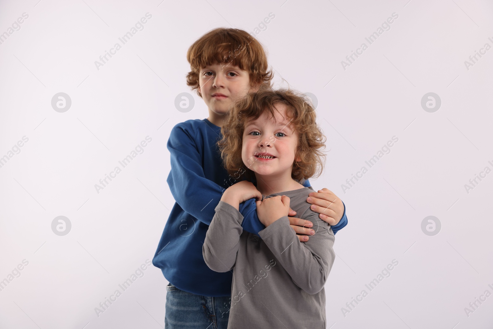 Cute little brothers hugging on white background Photo of Cute little brothers hugging on white background