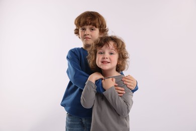 Photo of Cute little brothers hugging on white background