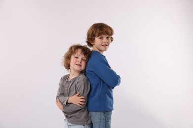 Photo of Cute little brothers posing on white background