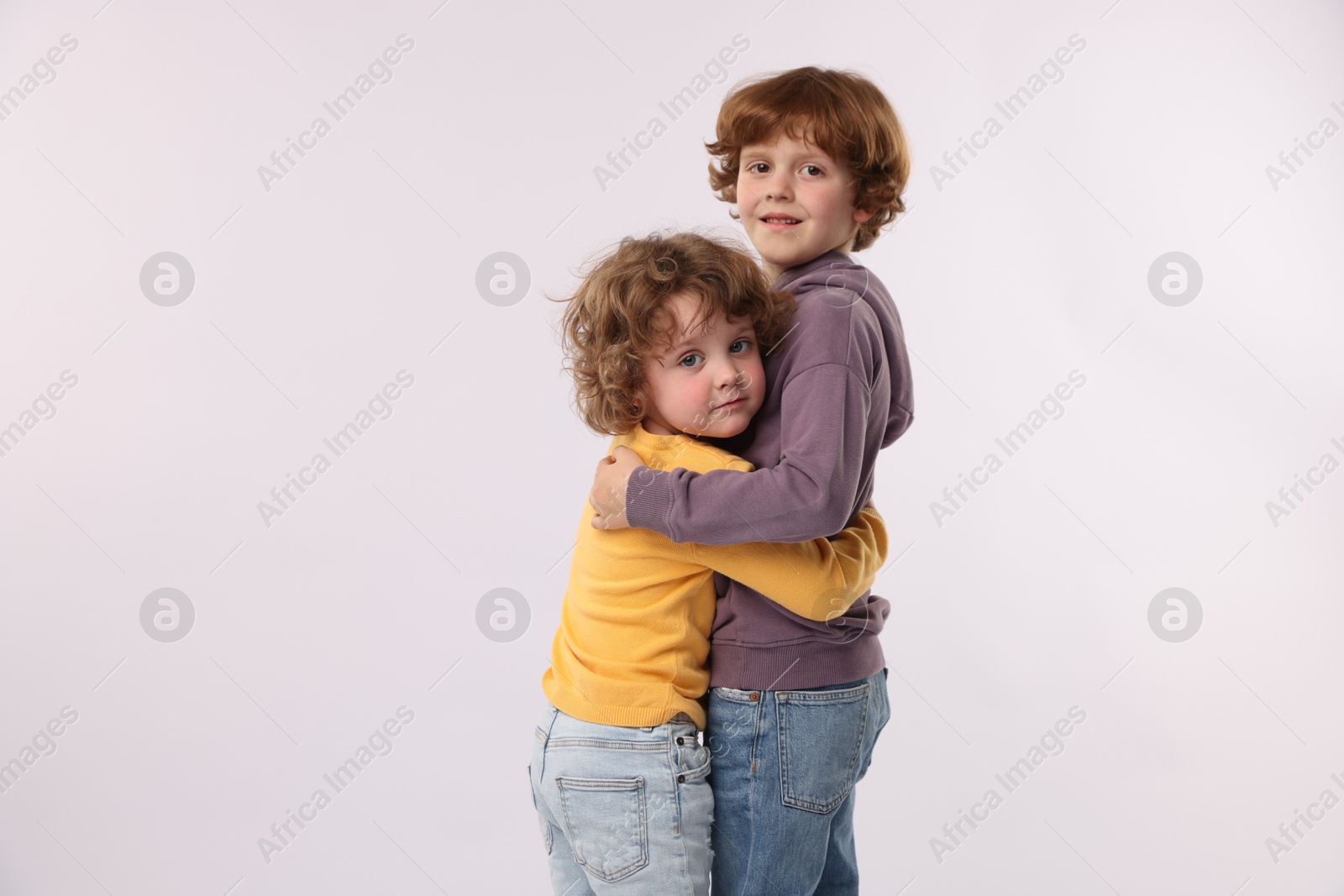Cute little brothers hugging on white background. Space for text Photo of Cute little brothers hugging on white background. Space for text