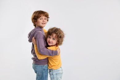 Photo of Cute little brothers hugging on white background