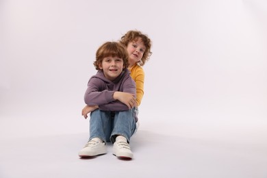 Photo of Cute little brothers posing on white background