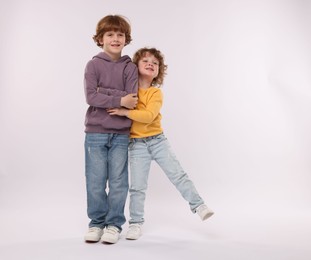 Photo of Cute little brothers hugging on white background