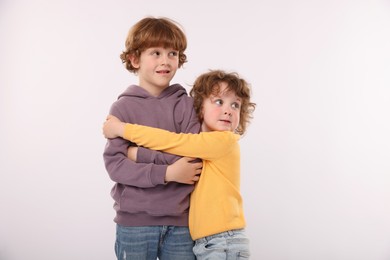 Photo of Cute little brothers hugging on white background
