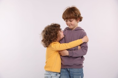 Photo of Cute little brothers hugging on white background