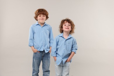 Photo of Cute little brothers together on light background