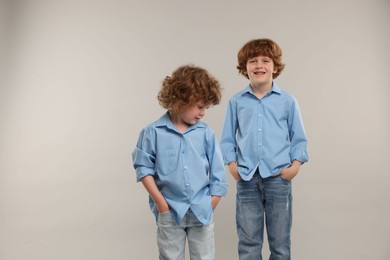 Photo of Cute little brothers together on light background