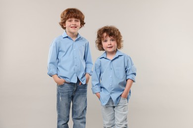 Photo of Cute little brothers together on light background