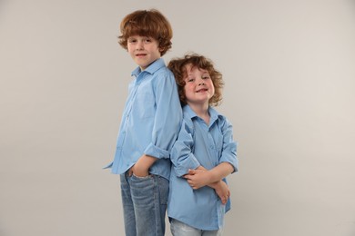 Photo of Cute little brothers together on light background
