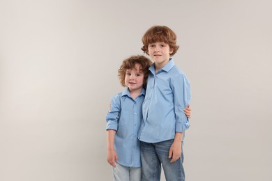 Photo of Cute little brothers together on light background. Space for text