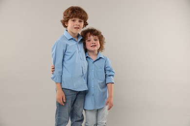 Photo of Cute little brothers together on light background. Space for text