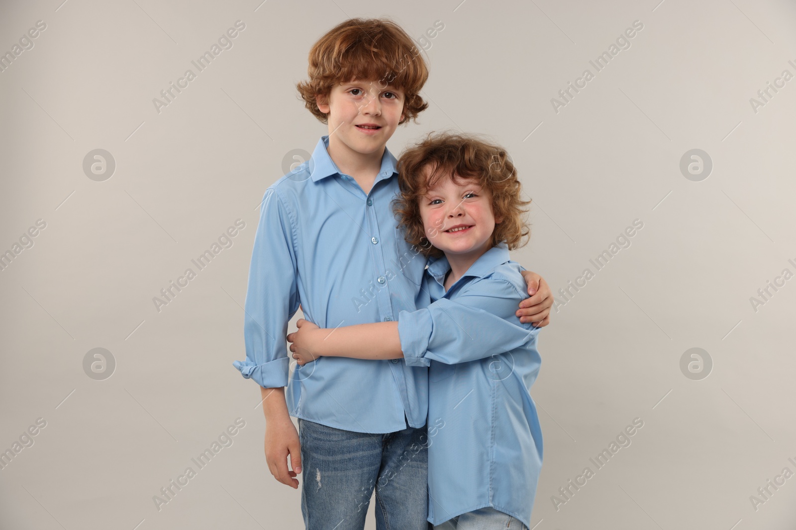 Cute little brothers hugging on light background Photo of Cute little brothers hugging on light background