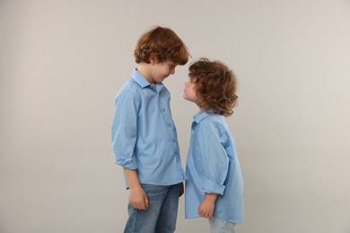 Photo of Two little brothers on light grey background